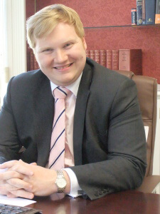 Robert Habbitts sitting at his desk and smiling to camera