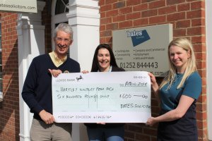 Steve Watling from Rotary Club of Hart watches as Jill McDonagh, Corporate Fundraiser at Naomi House & Jacksplace receives a cheque for £500.00 sponsorship from Laura Roberts, Marketing Director for Bates Solicitors 2018