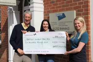 Steve Watling from Rotary Club of Hart watches as Jill McDonagh, Corporate Fundraiser at Naomi House & Jacksplace receives a cheque for £500.00 sponsorship from Laura Roberts, Marketing Director for Bates Solicitors 2018